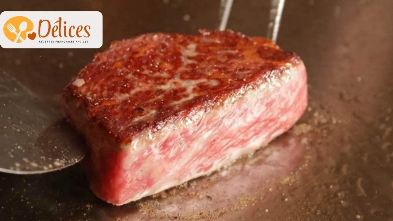 Gros plan sur un steak épais de bœuf de Kobe ou Wagyu, cuit (saisi) sur le bord, montrant un persillage exceptionnel. Image du bœuf de kobe prix 500g.