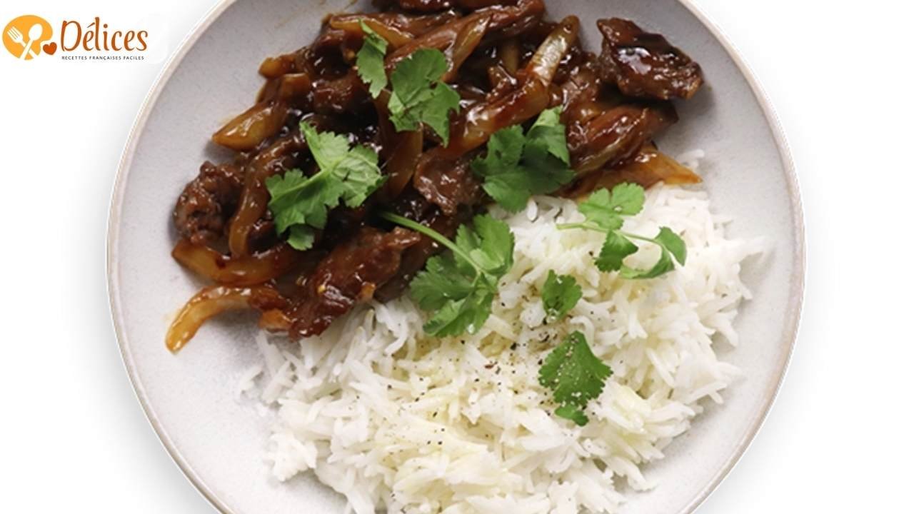 Bœuf aux oignons caramélisés, servi sur du riz blanc. Le plat est garni de coriandre.