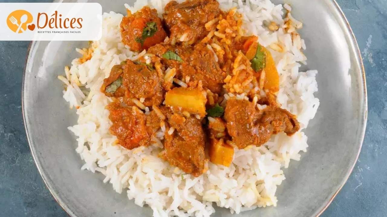 Gros plan sur un plat de riz blanc surmonté de morceaux de bœuf, de légumes (pommes de terre, carottes) et de sauce onctueuse à l'arachide. Image de la recette mafé boeuf traditionnelle.